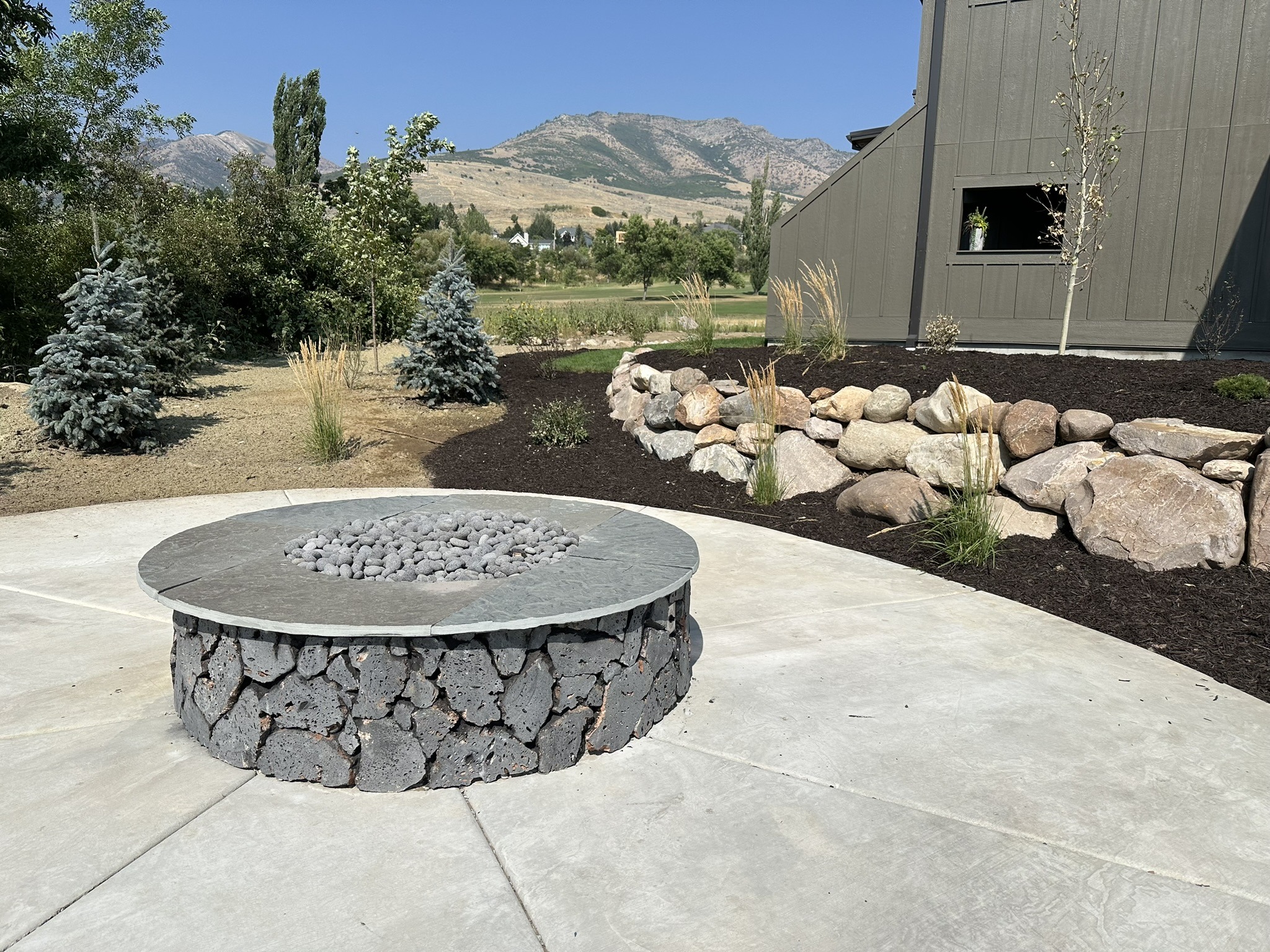 Backyard stone fire pit with mountain view