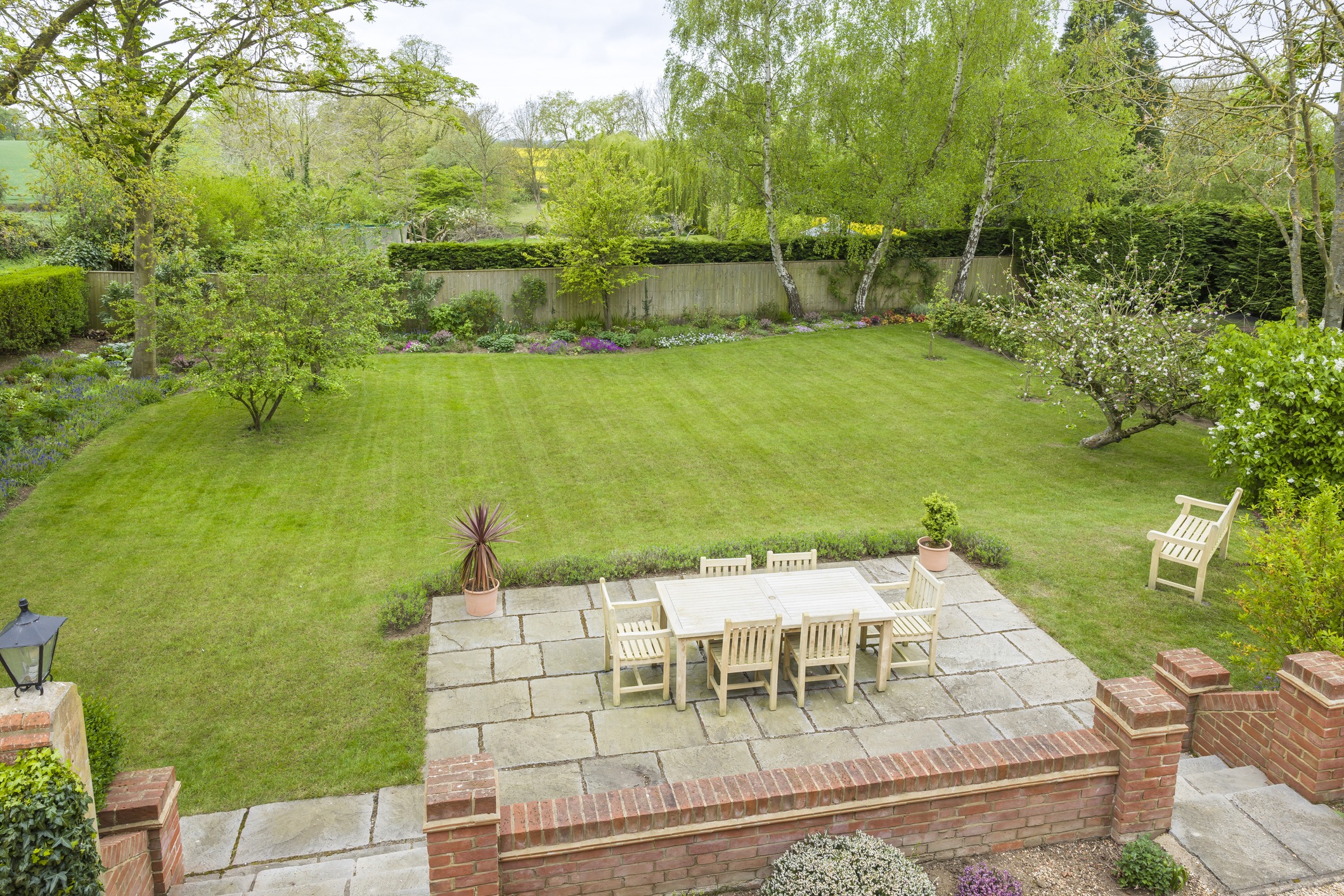 Spacious garden with patio and outdoor furniture.