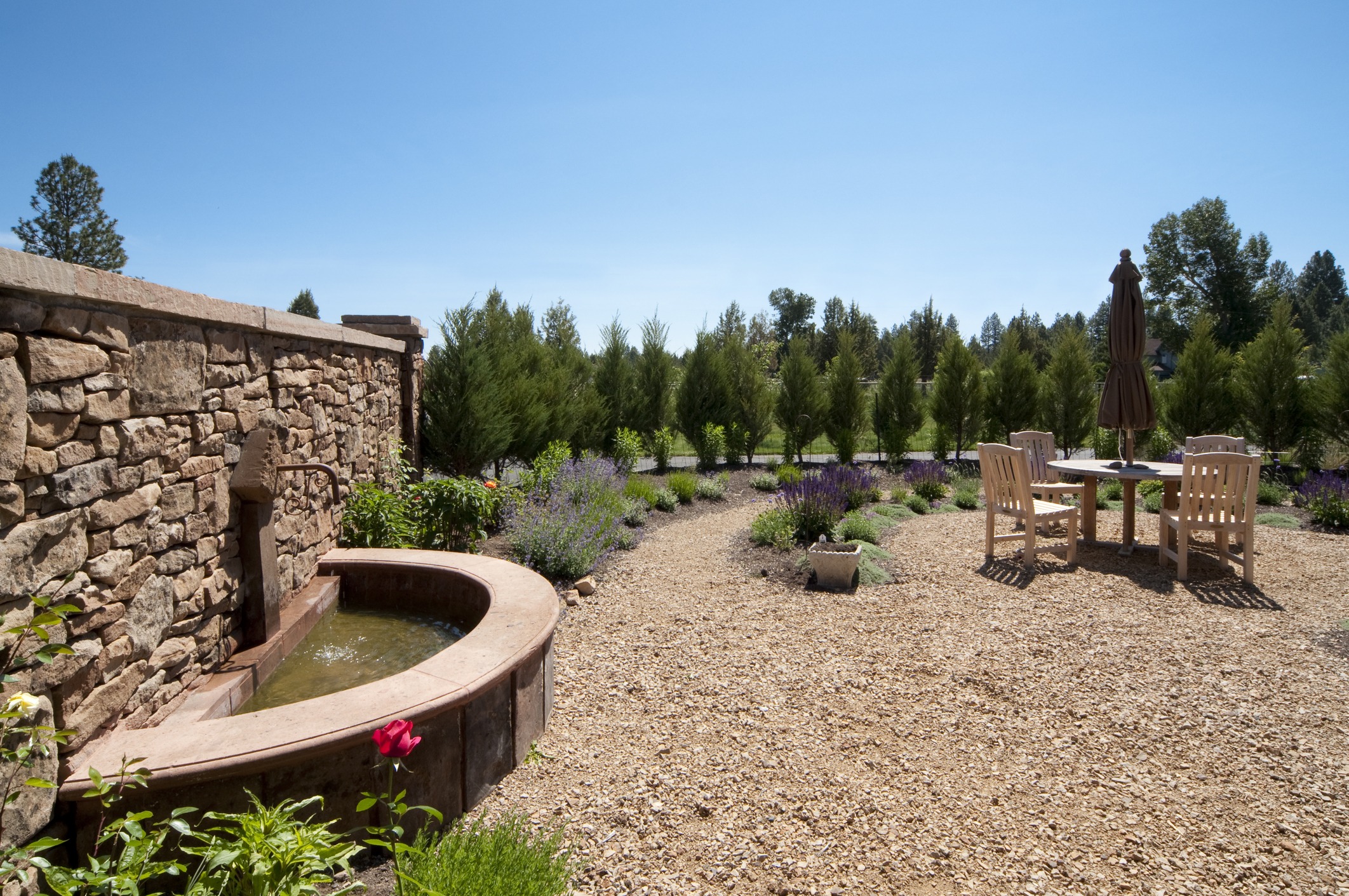 Tranquil garden with fountain and outdoor seating area.
