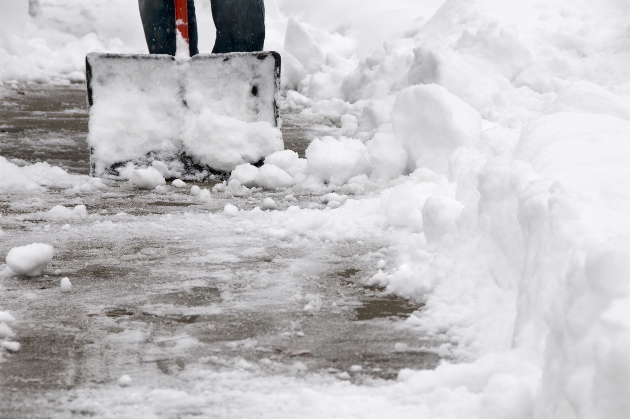 Person shoveling snow from sidewalk