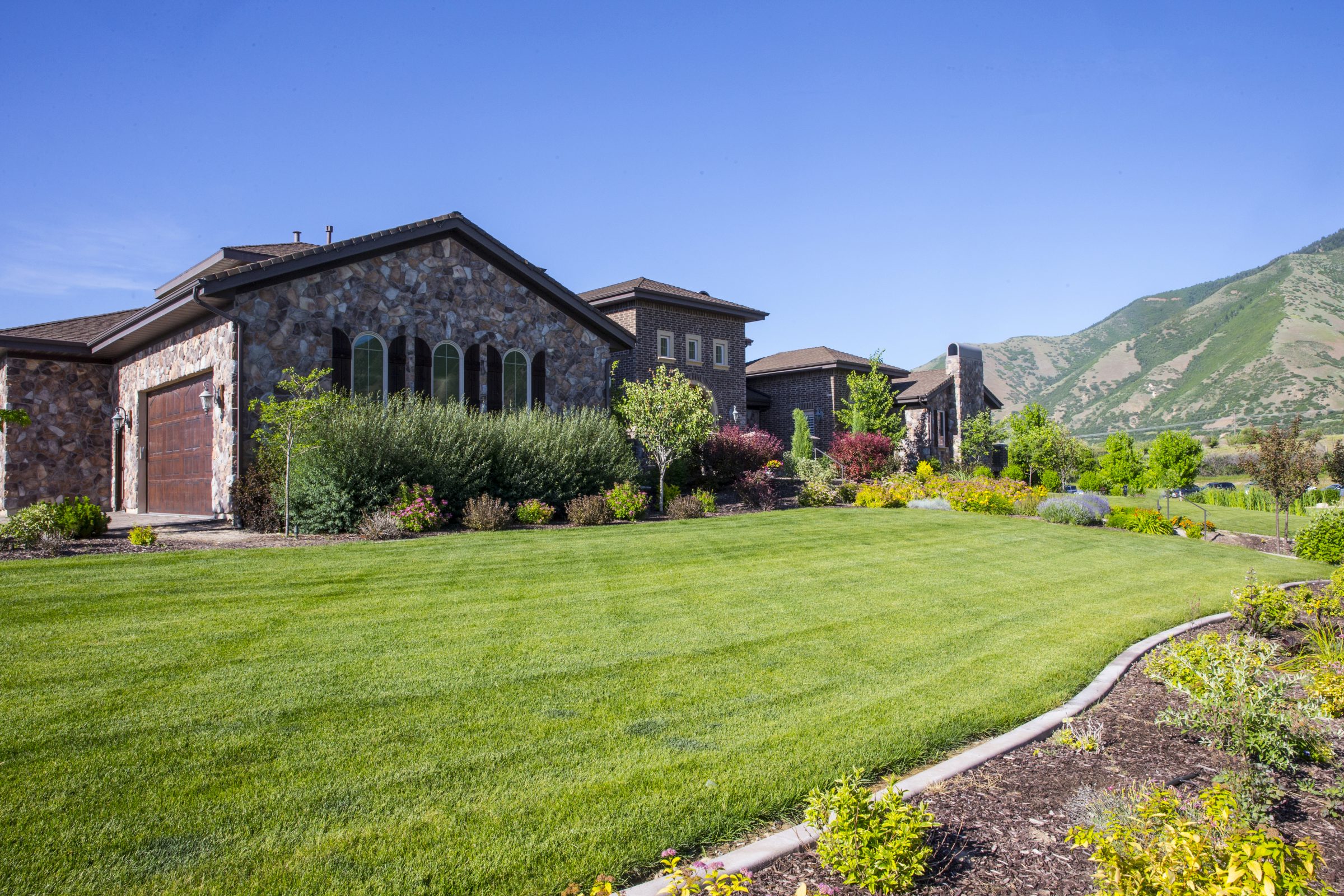 Stone house with landscaped yard and mountain view
