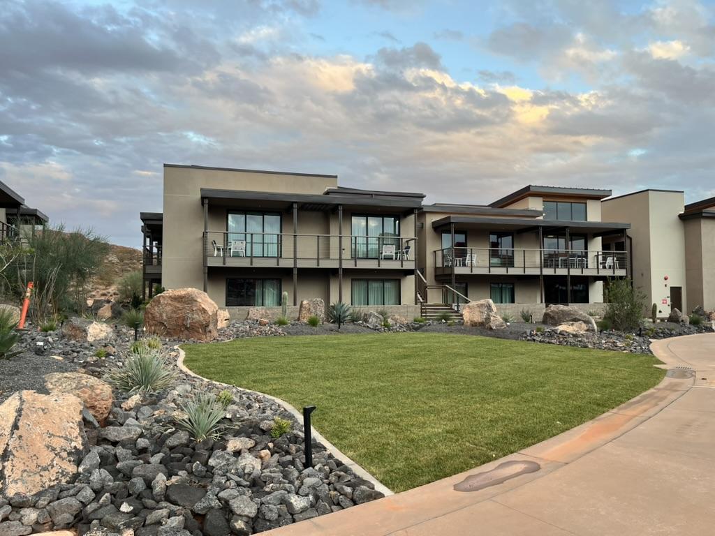 Multi building commercial property with manicured lawn, lava rock accents, desert plants, and modern architecture