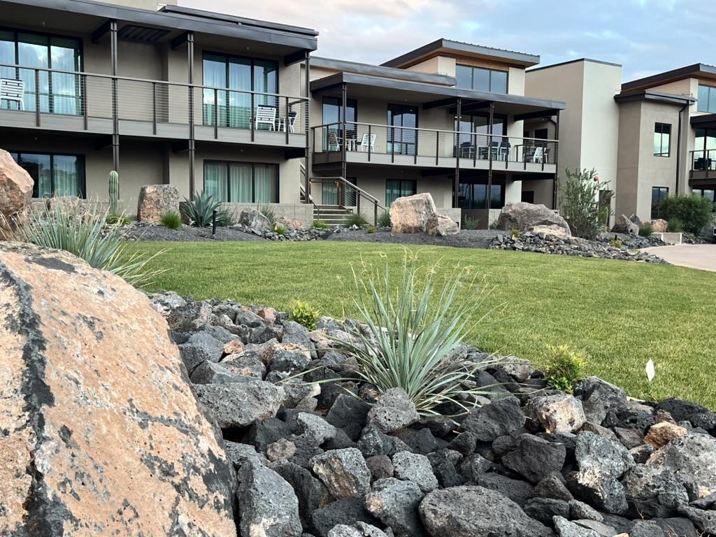 Resort-style commercial landscape with lawn, boulders, and native plants